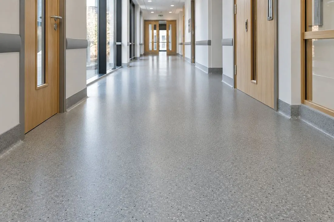 A speckled vinyl floor running along a bright commercial corridor